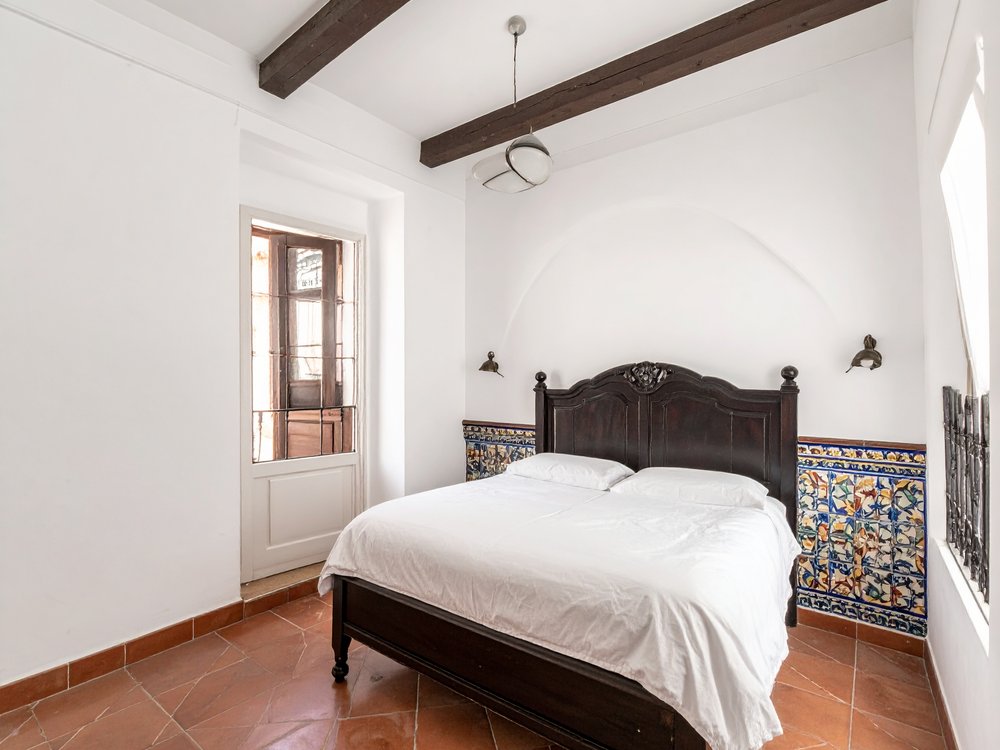 A traditional room with carved wood and Andalusian tiles in Santa Cruz. AI-generated image.