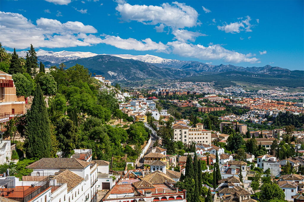 Panoramic view of Granada on a sunny day, with mountains on the horizon