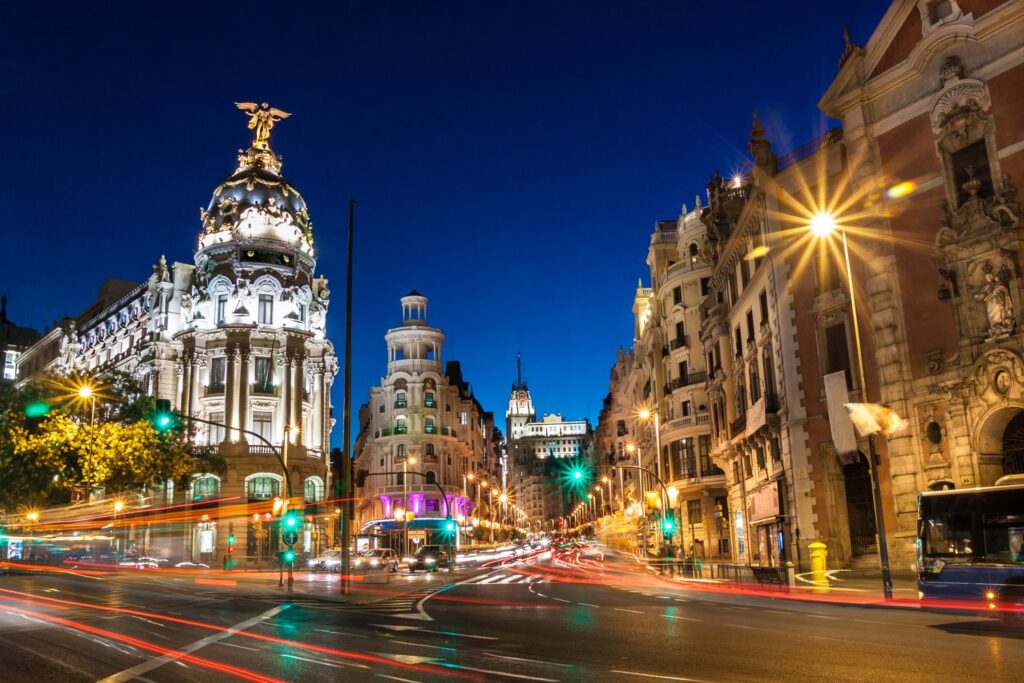 Gran Vía and the Metrópolis building light up the centre of Madrid at night.