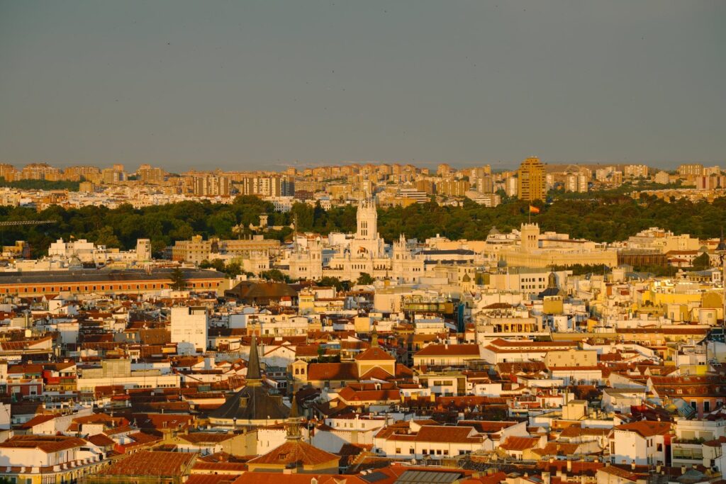 Historic rooftops stretch across central Madrid in the golden evening light.