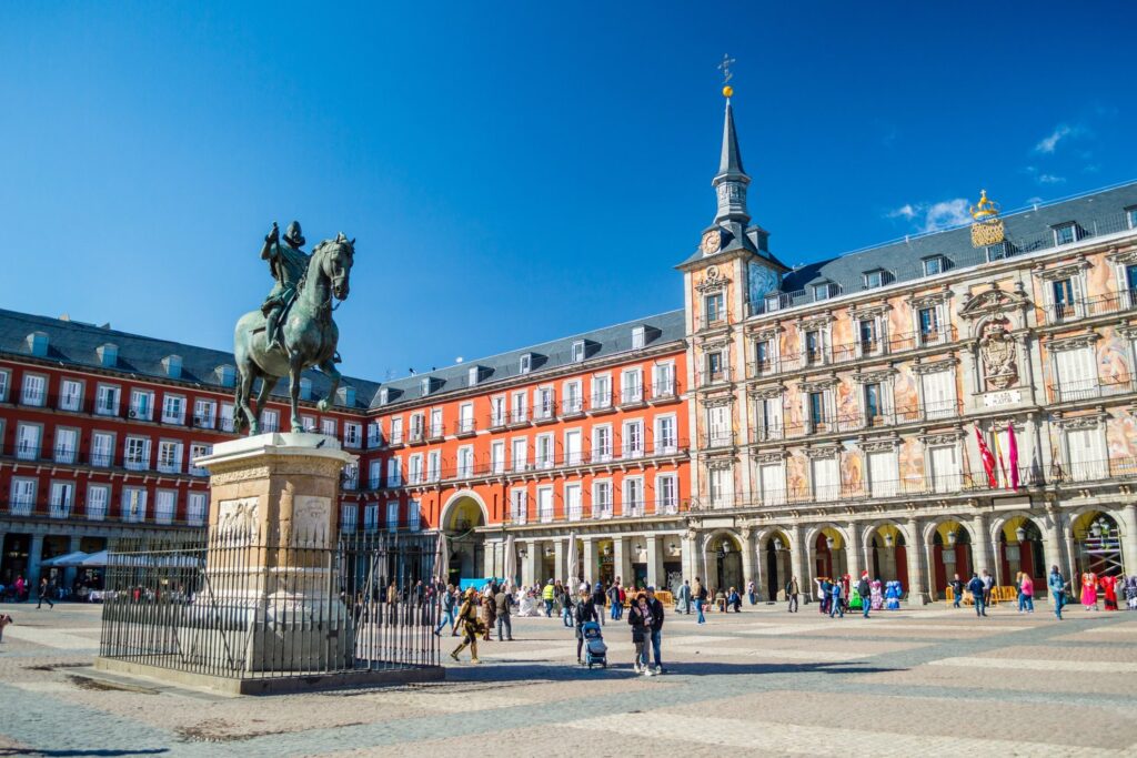 Plaza Mayor, completed in 1619, is framed by red arcaded houses and the statue of Philip III.