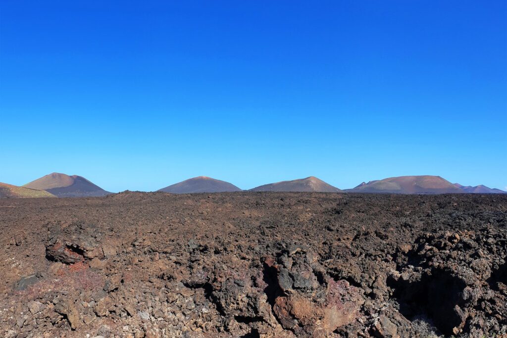 Black lava rocks and volcanic cones stretch to the horizon in Timanfaya National Park